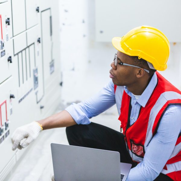 African American workers man ate work in electronic control room, machine technicians